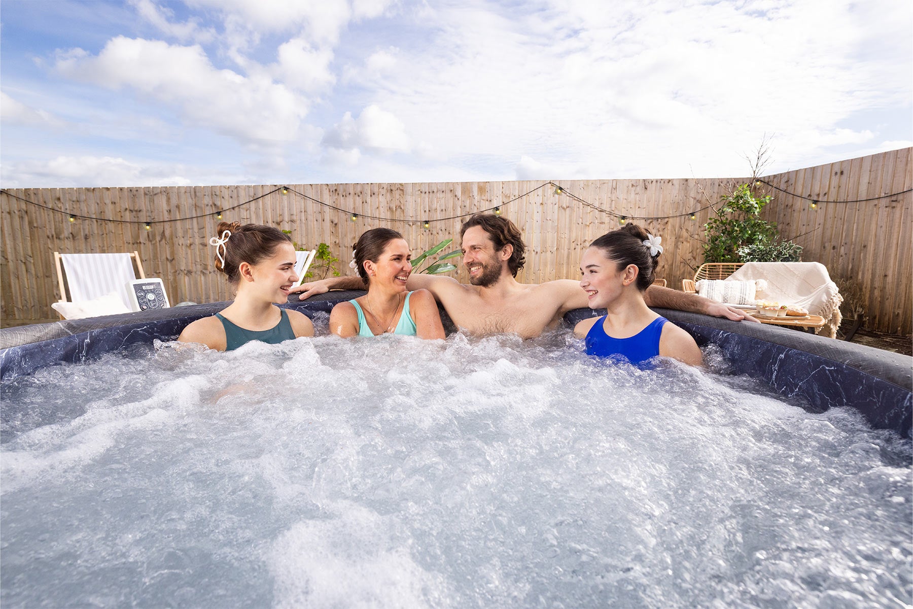 Four people family in a Lay-Z-Spa Copenhagen hot tub outdoors 