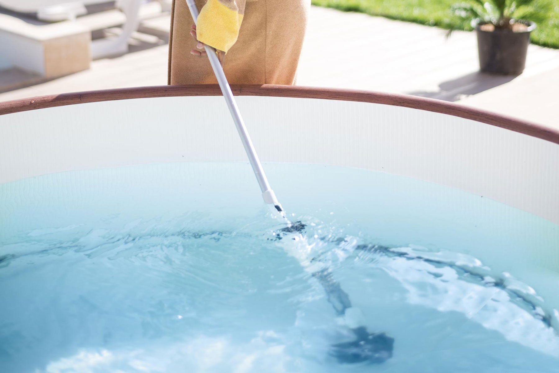 Cleaning the bottom of a Lay-Z-Spa with a vacuum.